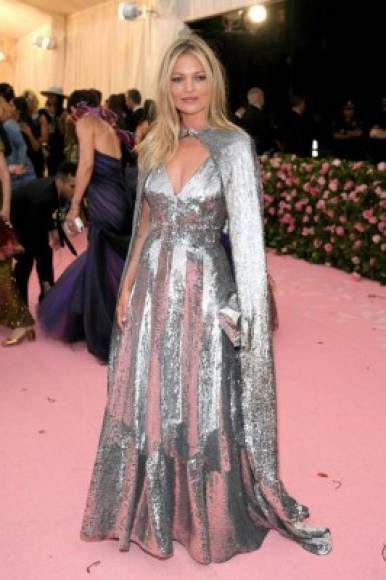 La supermodelo Kate Moss deslumbró con un diseño plateado que combinó con una capa larga y varios diamantes.