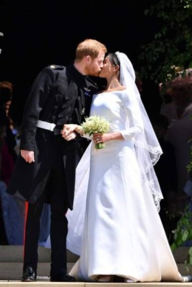 Britain's Prince Harry, Duke of Sussex kisses his wife Meghan, Duchess of Sussex as they leave from the West Door of St George's Chapel, Windsor Castle, in Windsor, on May 19, 2018 after their wedding ceremony. / AFP PHOTO / POOL / Ben STANSALL