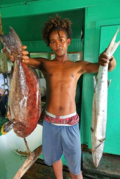 Un residente de la isla de Utila sostiene pescados para la venta. Foto Yoseph Amaya