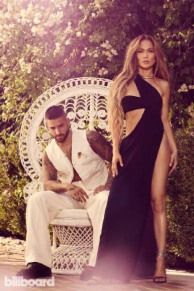 En esta imagen, se puede apreciar a una hermosa JLo parada frente a Maluma y luciendo un sensual vestido negro con una gran abertura que deja ver sus bien formadas piernas.