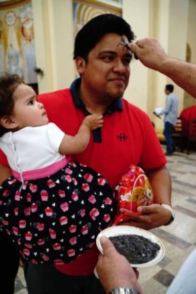 Un padre recibe su marca en compañía de su pequeña hija.