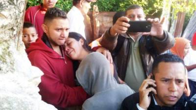 Una mujer llora en el hombro de un joven tras la muerte de siete personas en Comayagüela.