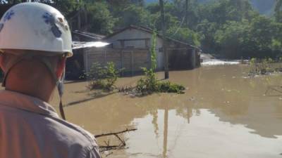 Un bombero observa una zona afectada por el desborde del río.