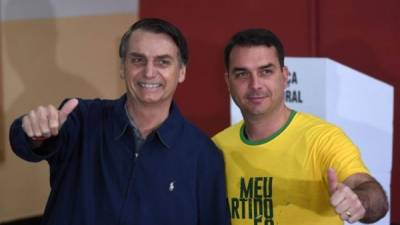 El presidente de Brasil, Jair Bolsonaro, junto a su hijo mayor y senador electo, Flávio./AFP.