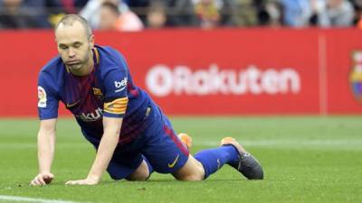 Barcelona's Spanish midfielder Andres Iniesta lies on the field during the Spanish league footbal match between FC Barcelona and Valencia CF at the Camp Nou stadium in Barcelona on April 14, 2018. / AFP PHOTO / LLUIS GENE