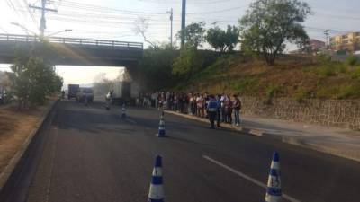 Obreros varados por un momento durante el decomiso de dos vehículos en Tegucigalpa.