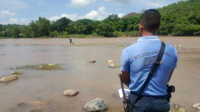 Un elemento de la Policía observa cómo sacan el cadáver de la mujer.