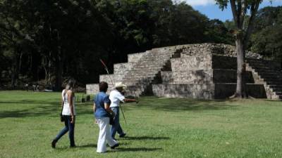 Tres turistas recorren Ruinas de Copán, uno de los sitios más representativos.