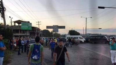 Algunas personas buscan llegar a su trabajo hacia San Pedro Sula a pie debido a la toma de carretera.