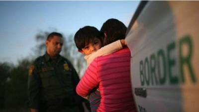 Foto de una inmigrante con su hijo en la frontera de México con Estados Unidos. Foto referencial de AFP
