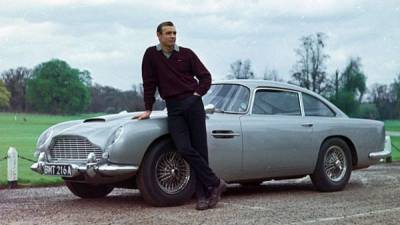 El actor Sean Connery, el primero en intepretar al agente secreto James Bond en el cine, posa junto a su famoso Aston Martin.