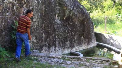 De una roca sale el agua que cae en un pozo, el cual mantienen limpio.