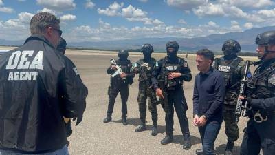 Jorge Luis Aguilar es resguardado por agentes de la DEA y de la Fuerza Aérea Hondureña.