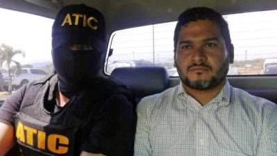 This handout picture released by the Honduran Technical Agency of Criminal Investigation (ATIC) shows Roberto Castillo Mejia (L), the ninth suspect involved in the murder of activist Berta Caceres, being escorted by members of the ATIC in Tegucigalpa on March 3, 2018.According to the ATIC Castillo, an electrical engineer, who was the executive president of Desarrollos Energeticos (DESA), an electricity company involved in the construction of a hydro-electric dam against which murdered Caceres had campaigned, could be the intellectual author of the crime. / AFP PHOTO / ATIC / HO / RESTRICTED TO EDITORIAL USE - MANDATORY CREDIT 'AFP PHOTO / ATIC' - NO MARKETING NO ADVERTISING CAMPAIGNS - DISTRIBUTED AS A SERVICE TO CLIENTS