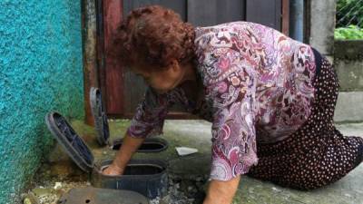 La señora Gloria Cerrato revisa la presión de las válvulas de agua potable de las casas afectadas. Foto: Jordan Perdomo.