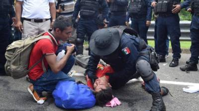 Un policía ofrece primeros auxilios a un migrante que sufre un desmayo luego de que fuera interceptado por autoridades. EFE