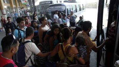 Varias personas se alistan para abordar una unidad en la terminal de San Pedro Sula. Foto de archivo.