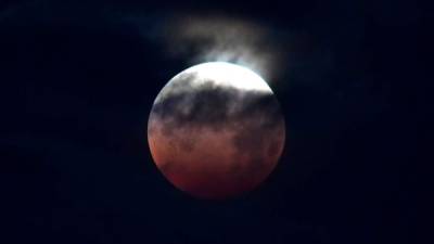 Una luna llena, en su punto más cercano a la Tierra, y un eclipse lunar total coincidieron la madrugada de miércoles en la llamada 'superluna roja', un espectáculo hermoso que iluminó y oscureció el cielo.