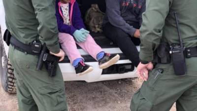 Dos agentes de la Patrulla Fronteriza mientras atienden a unos niños en un punto del área conocido como Quitobaquito, en la frontera de Arizona con México. EFE