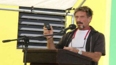 FILE - In this Nov. 8, 2012 file photo, John McAfee speaks at a ceremony for the official presentation of equipment at the San Pedro Police Station in Ambergris Caye, Belize. McAfee, 67, has been identified as a 'person of interest' in the killing of his neighbor, 52-year-old Gregory Faull. Police are urging McAffe to come in for questioning. The anti-virus company founder said on Monday, Dec. 3, 2012, he has left Belize and is still on the run, hiding from police out of fear they want to kill him. (AP Photo/Ambergris Today Online-Sofia Munoz, File)