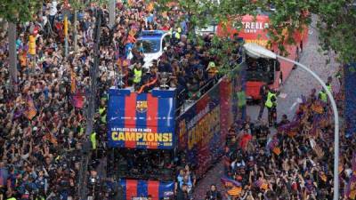 Barcelona football club players and staff parade aboard an open-top bus to celebrate their 25th La Liga title in Barcelona on April 30, 2018.Barcelona won their 25th La Liga title after a 4-2 win against Deportivo La Coruna. / AFP PHOTO / LLUIS GENE