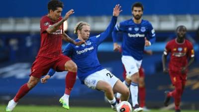 Roberto Firmino lucha por el balón con Tom Davies, del Everton. Foto AFP