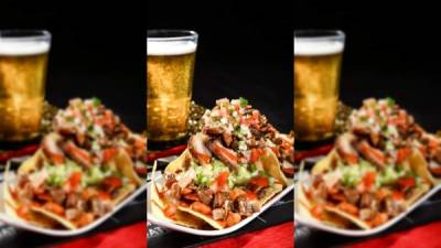 Sirva los nachos con chimol, guacamole y carne de cerdo.