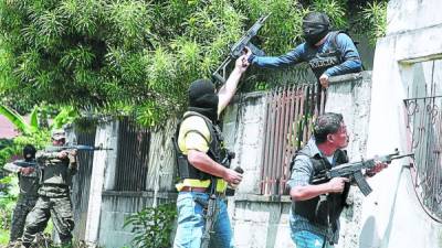 Agentes de la DNIC cuando ingresaban ayer a una de las viviendas allanadas en la colonia Reparto Los Angeles del sector Rivera Hernández.