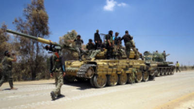 Rebel fighters stand on top of two tanks reportedly confiscated from an army barracks in the northwestern Syrian city of Sermin on June 14, 2013. The United States sharply toughened its line on Syria, promising rebels weapons for the first time, after saying it had evidence the regime had used chemical weapons, a charge Damascus dismissed as 'lies.' AFP PHOTO/MOHAMED KADDOUR