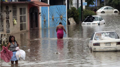 Los residentes caminan a través de una calle inundada en Acapulco, estado de Guerrero, México, el 26 de septiembre de 2013.