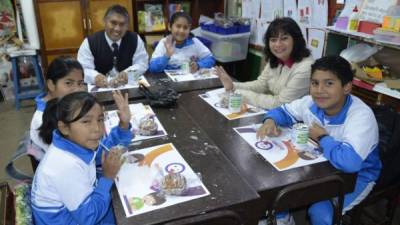 Menores reciben merienda escolar en Perú.