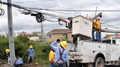 Labor. Empleados de la EEH reparan el tendido eléctrico en San Pedro Sula. archivo.