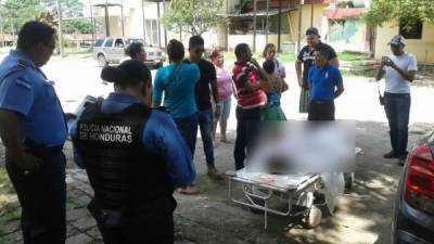 Autoridades policiales, familiares de la víctima observan el cuerpo de Rodimiro Fuentes en las instalaciones del Hospital de El Progreso.