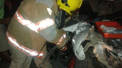 Un elemento del Cuerpo de Bomberos trabaja para sacar a las víctimas.