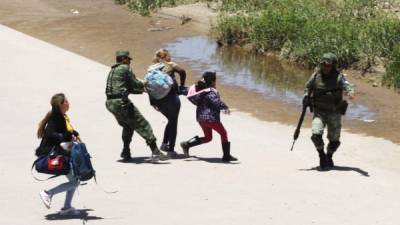 Mexican National Guard members prevent Central American migrants from crossing the Rio Bravo, in Ciudad Juarez, State of Chihuahua, on June 21, 2019. - Mexican President Andres Manuel Lopez Obrador suggested Friday he and US counterpart Donald Trump should hold their first meeting in September to review progress on the countries' recent migration deal. (Photo by HERIKA MARTINEZ / AFP)