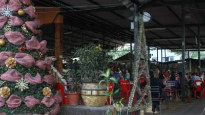 Sampedranos disfrutando de rica comida en la plaza típica en la tercera avenida. Hay adornos alusivos a la época.