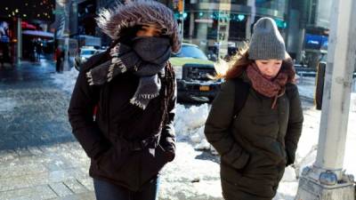 Peatones se protegen del frío con sus abrigos en Nueva York (Estados Unidos), hoy 5 de enero de 2018. El aeropuerto JFK de Nueva York, uno de los principales puntos de entrada a Estados Unidos, reanudó hoy sus operaciones después de quedar suspendidas el jueves por la fuerte tormenta que sufrió la ciudad y sus alrededores. EFE/ Justin Lane