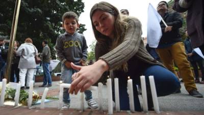 Bogotanos encienden velas en memoria de las víctimas que perecieron en el atentado.