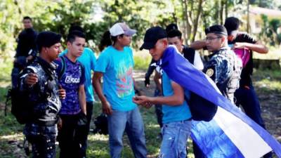 Policías guatemaltecos ordenan a migrantes hondureños regresar a la frontera entre Guatemala y Honduras.