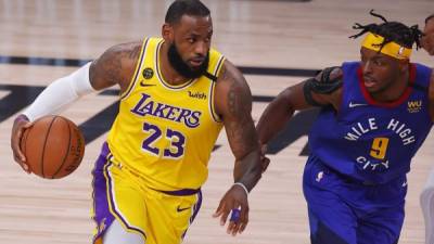 LeBron James conduce la pelota ante la marca de Jerami Grant de los Denver Nuggets. Foto AFP