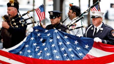 Agentes de policía y bomberos de Nueva York rinden homenaje a las víctimas de los atentados. AFP