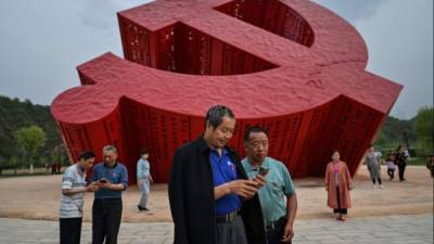 Fotografía de China de personas junto a un monumento de la hoz y el martillo en Nanniwan. AFP