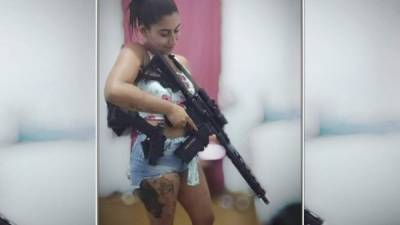 Rayane Cardozo da Silveira sostiene una pistola, que parece ser un rifle.