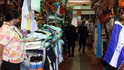 Dos elementos policiales supervisando algunos puestos de venta en uno de los mercados sampedranos.