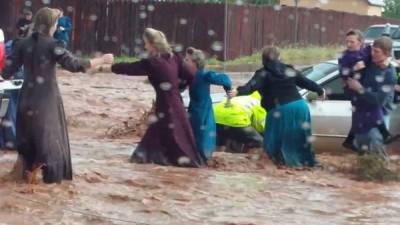 Un grupo de mujeres trata de huir de la corriente tras la repentina inundación que dejó 8 personas muertas en Utah.