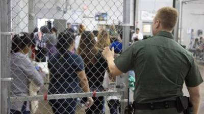 This image released by the US Immigration and Customs Enforcement (ICE) shows a Homeland Security Investigations (HSI) officer guarding suspected illegal aliens on August 7, 2019. Officers detained approximately 680 aliens who were unlawfully working at at seven agricultural processing plants across Mississippi. - US officials said that some 680 undocumented migrants were detained in a major series of raids on August 7, at food processing plants in the southeastern state of Mississippi, part of President Donald Trump's announced crackdown on illegal immigration. 'Special agents executed administrative and criminal search warrants resulting in the detention of approximately 680 illegal aliens,' said Mike Hurst, US Attorney for the Southern District of Mississippi. (Photo by HO / US Immigration and Customs Enforcement / AFP) / RESTRICTED TO EDITORIAL USE - MANDATORY CREDIT 'AFP PHOTO / US Immigration and Customs Enforcement' - NO MARKETING NO ADVERTISING CAMPAIGNS - DISTRIBUTED AS A SERVICE TO CLIENTS