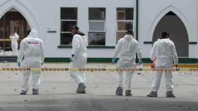 Peritos forenses inspeccionan el lugar donde un carro bomba causó una explosión este jueves en la Escuela General Santander de la Policía en Bogotá (Colombia). EFE