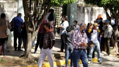 Personas esperan hoy para ser atendidas o para obtener información sobre sus familiares enfermos, frente al Instituto Nacional Cardiopulmonar (Hospital del Tórax) en Tegucigalpa. EFE