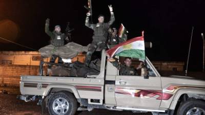 Miembros del convoy de soldados kurdos iraquíes entrando en la ciudad de Kobani, asediada por Isis.