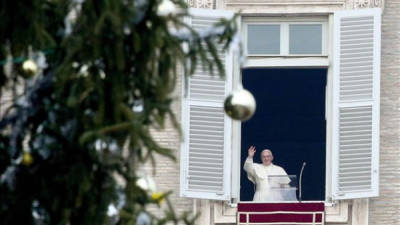 El papa Francisco saluda desde el balcón de su apartamento en El Vaticano, tra el rezo del Ángelus. EFE